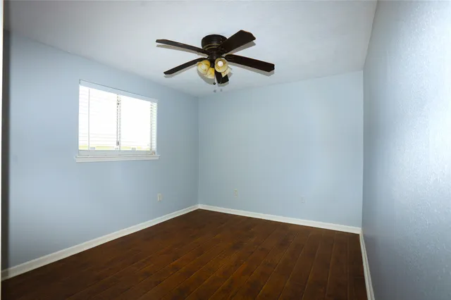 a view of a room with a window and a ceiling fan