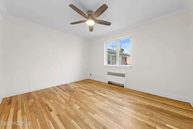 a view of a big room with wooden floor and a ceiling fan