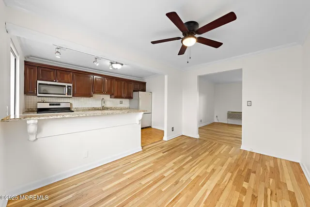 a kitchen with stainless steel appliances kitchen island granite countertop a refrigerator and a stove top oven