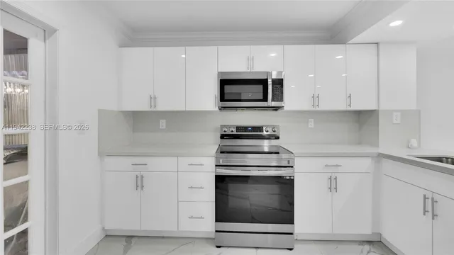 a kitchen with white cabinets and stainless steel appliances