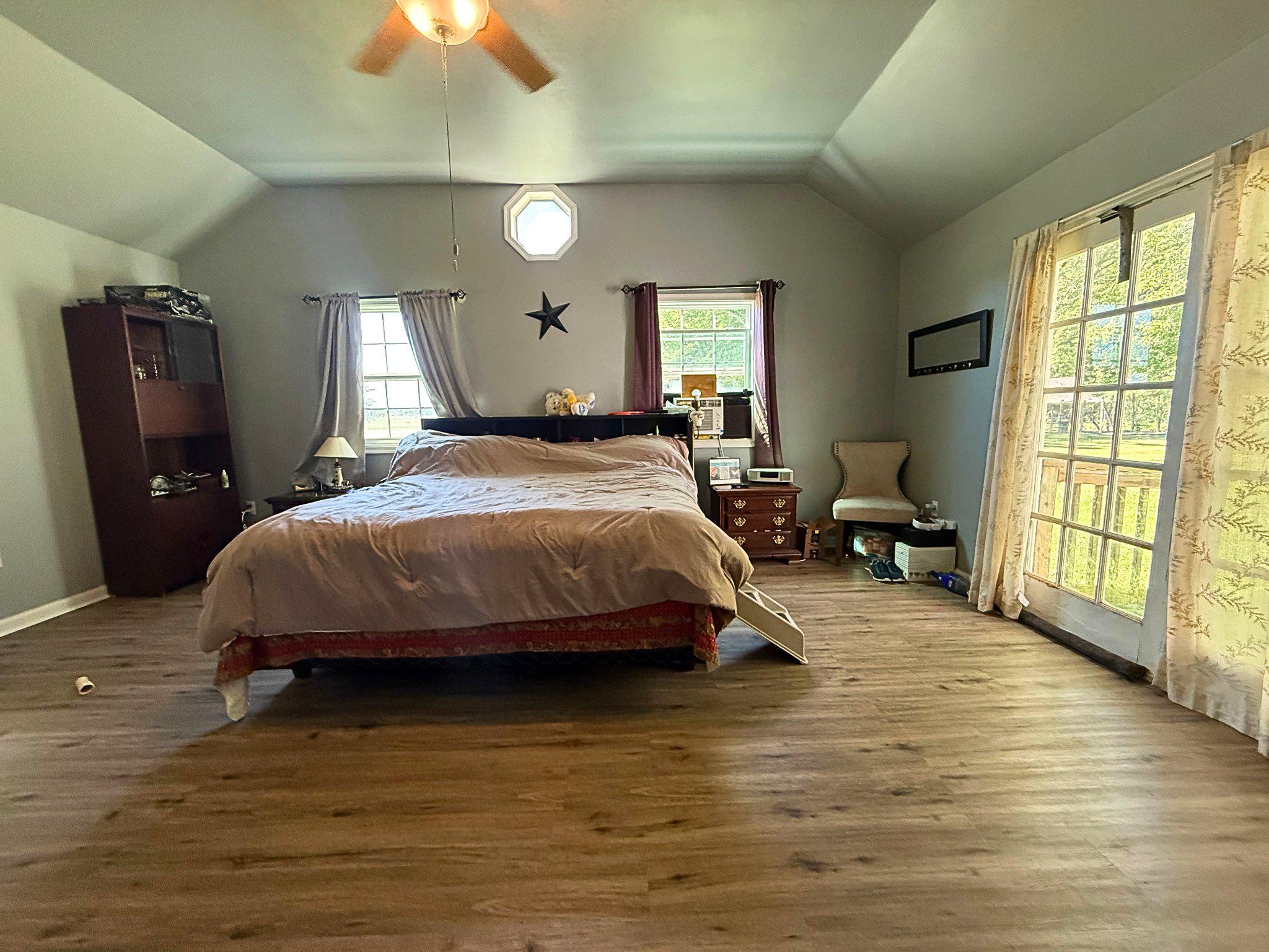 4818 Piney Neck Road Rock Hall, MD 21661 - Photo 12 of 24 a bedroom with a bed dresser and a chandelier