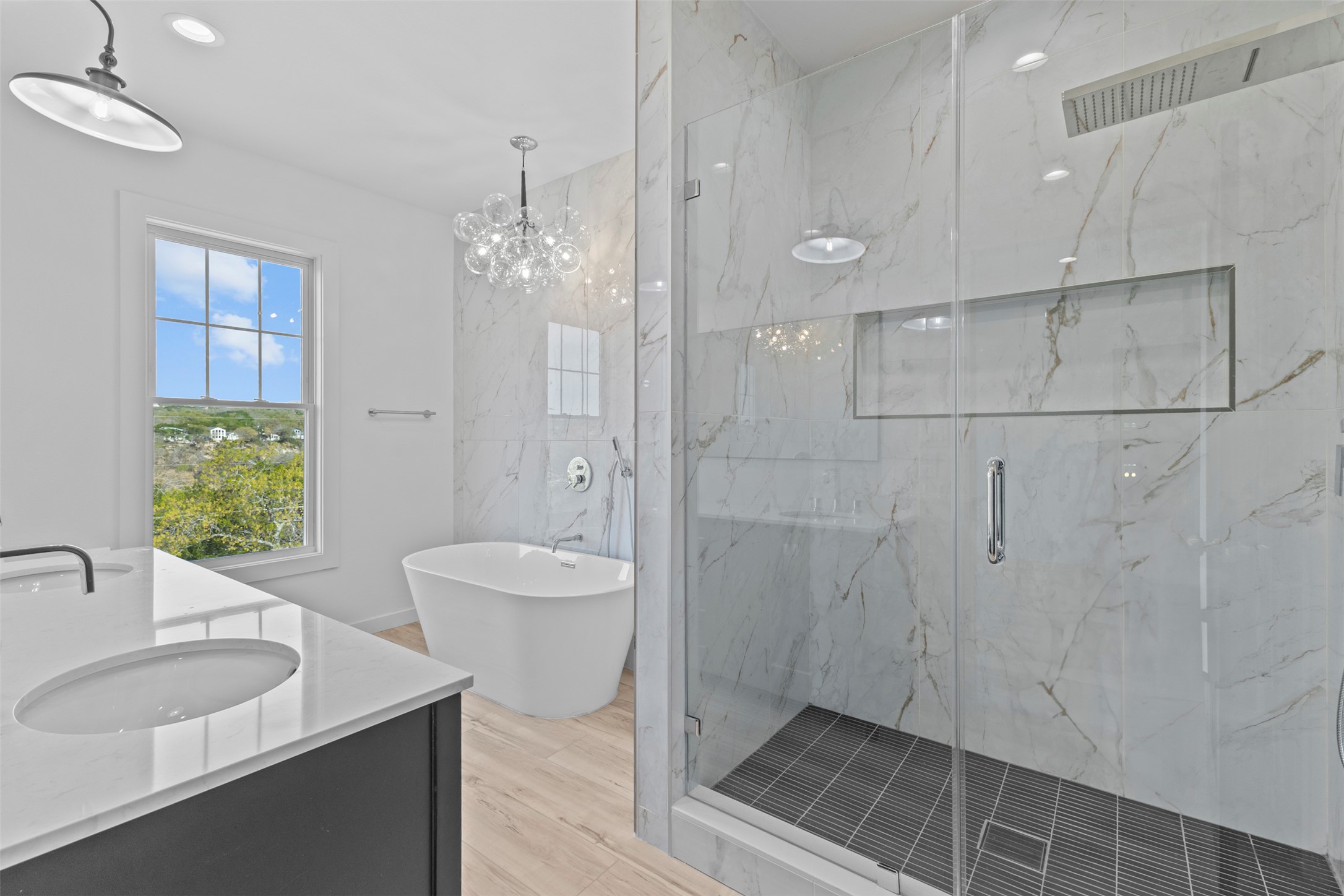 11005 Beach Road Leander, TX 78641 - Photo 14 of 40 Bathroom with a marble finish shower, double vanity, a freestanding tub, light wood finished floors, and hanging lights