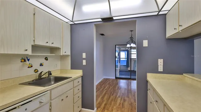 a kitchen with a sink a refrigerator and cabinets