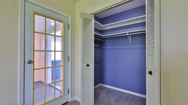 an empty room with mirror and fan