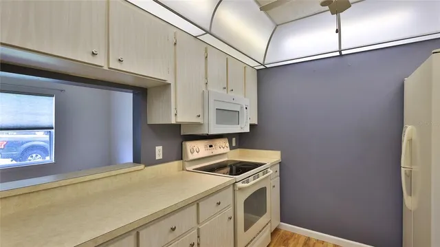 a kitchen with stainless steel appliances granite countertop a sink a stove and white cabinets