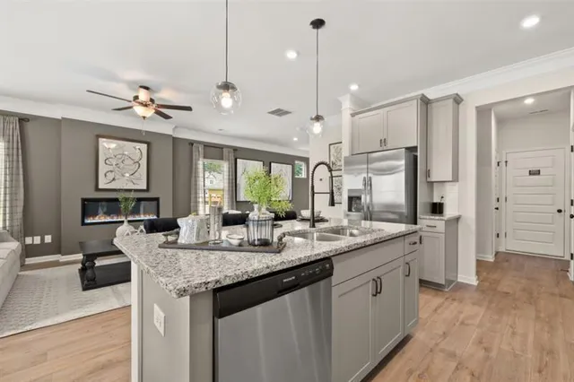 a kitchen with granite countertop kitchen island stainless steel appliances a sink stove and kitchen island