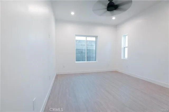 an empty room with a window and a ceiling fan