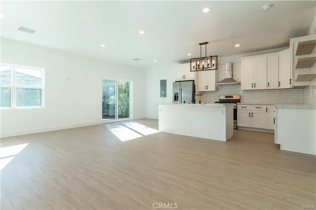a view of a kitchen with a sink wooden cabinets and a window