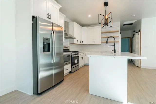 a kitchen with kitchen island a counter top space a sink and stainless steel appliances