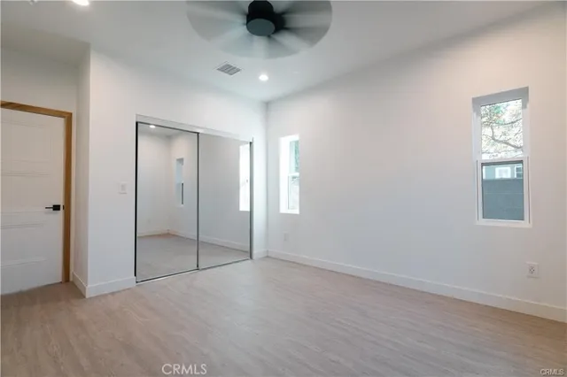 an empty room with fan and windows