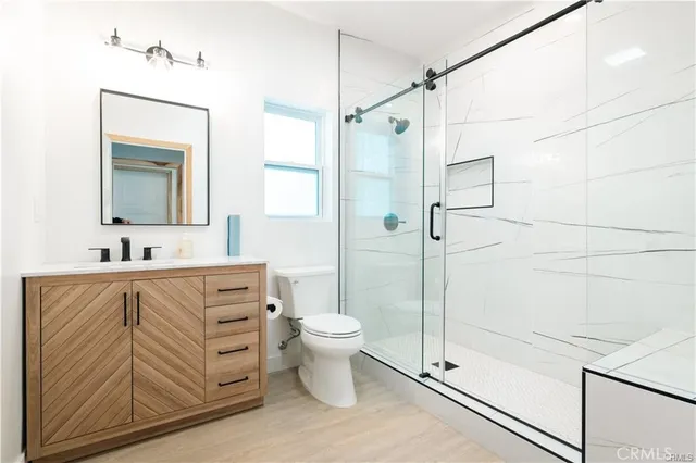 a bathroom with a double vanity sink toilet and shower