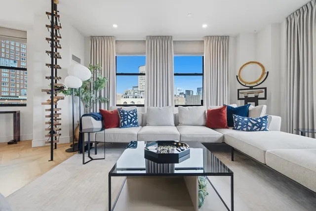 a living room with furniture kitchen view and a chandelier