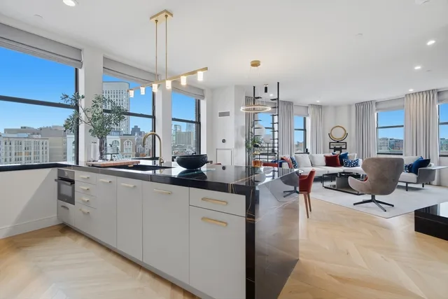 a living room with furniture a large window and a chandelier