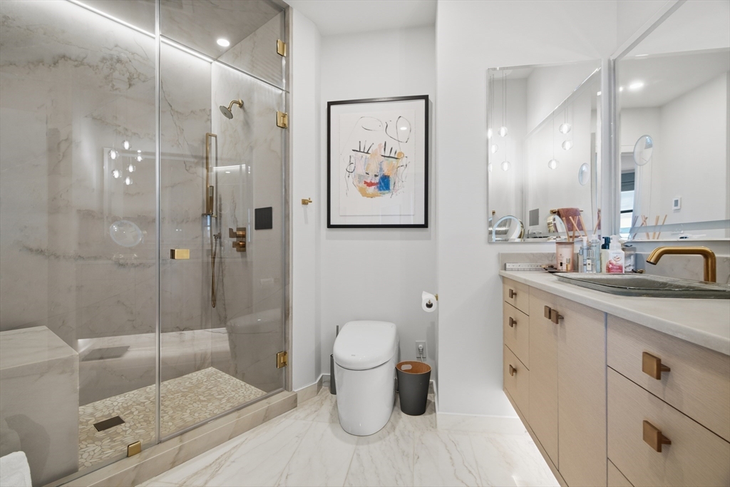 285 Columbus Avenue, Unit PH 805 Boston, MA 02116 - Photo 24 of 42 a bathroom with a granite countertop sink a toilet and shower