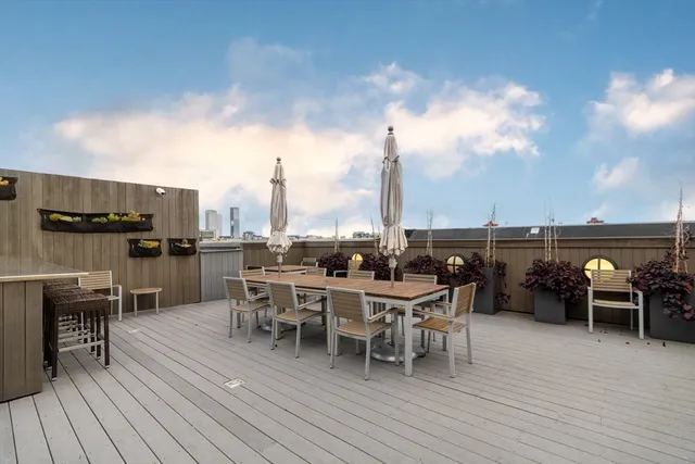 a roof deck with table and chairs
