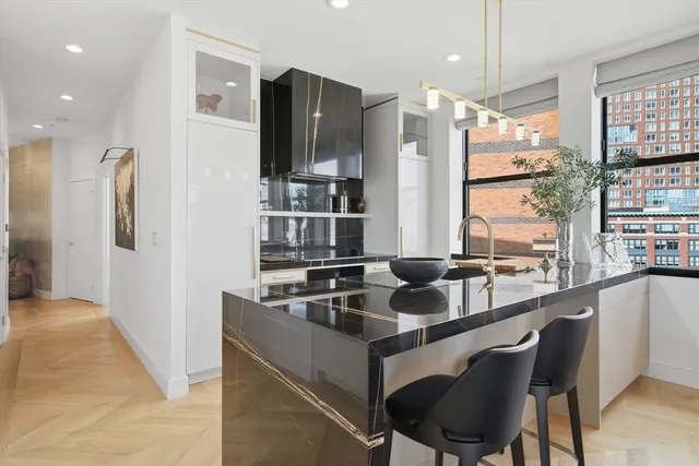 a dining hall with stainless steel appliances granite countertop a sink and a refrigerator