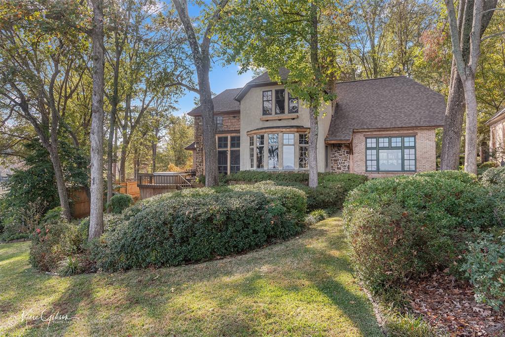 3045 Risinger Drive Shreveport, LA 71119 - Photo 8 of 40 a view of a white house next to a yard with plants and trees