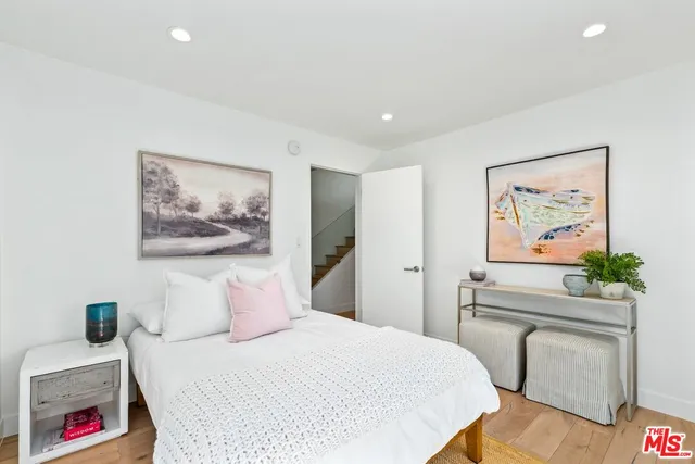 a bedroom with a bed and a painting on the wall