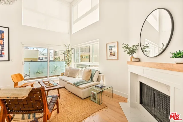 a living room with furniture a fireplace and a floor to ceiling window
