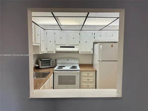a kitchen with white cabinets and white appliances