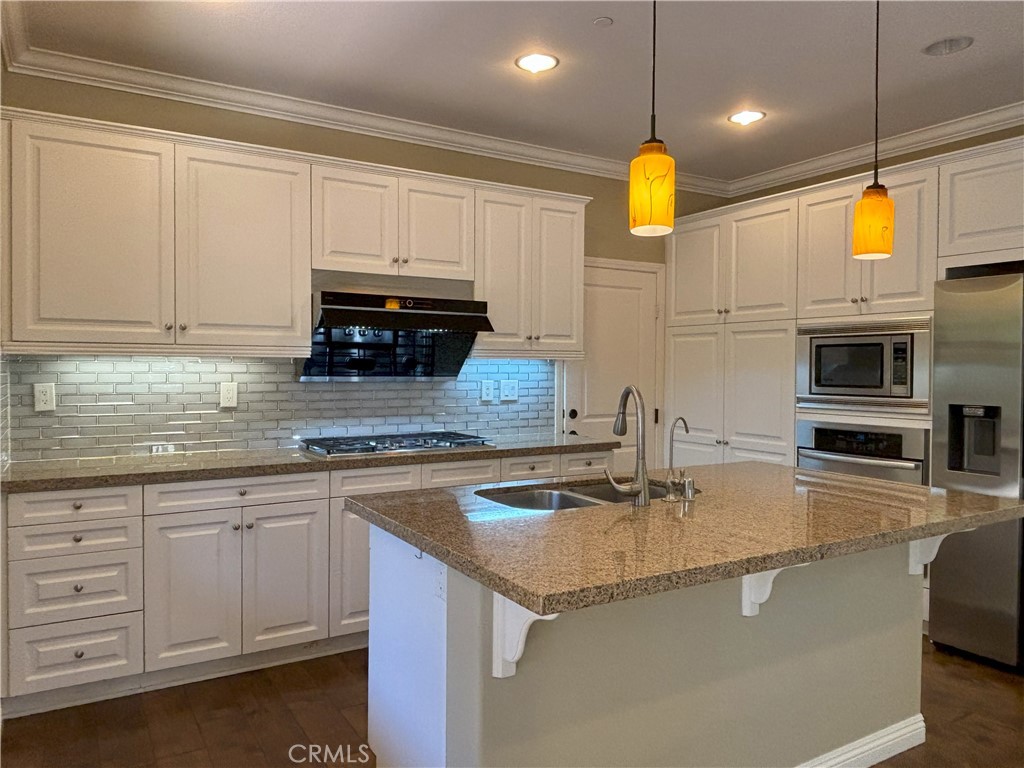 25 Bridge Trail Irvine, CA 92618 - Photo 2 of 25 a kitchen with kitchen island granite countertop a sink a counter top space cabinets and stainless steel appliances