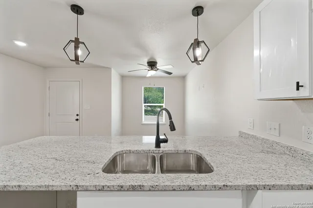 a kitchen with sink cabinets and chandelier