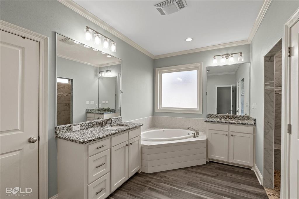 143 Oak Alley Road Stonewall, LA 71078 - Photo 21 of 38 Dual vanity with granite countertops, wood-finish flooring, built-in soaking tub, and a separate walk-in shower with tile surround