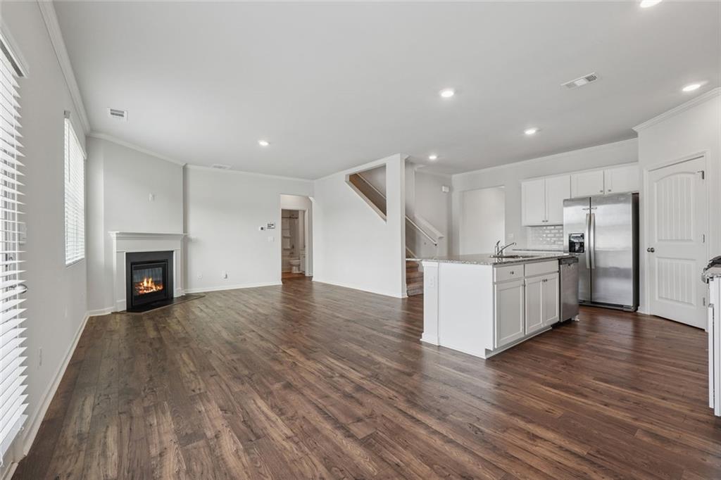 96 Quail Bend Way Dallas, GA 30157 - Photo 14 of 57 a view of an empty room with wooden floor and a kitchen