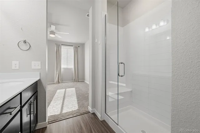 a bathroom with a glass shower door and a sink