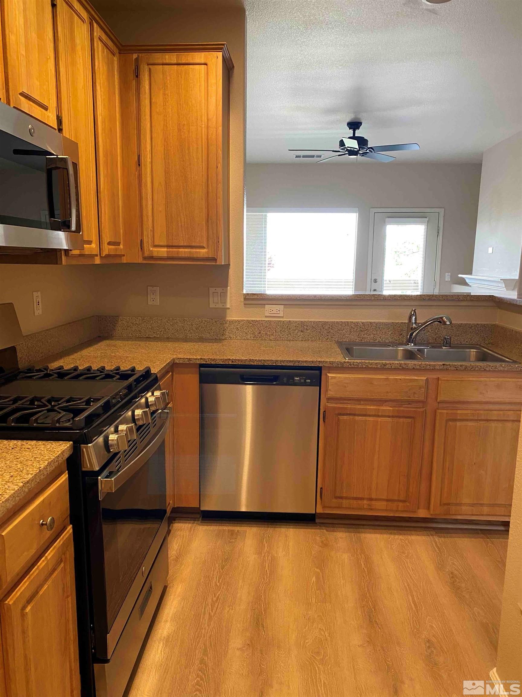 900 S Meadows, Unit 3722 Reno, NV 89521 - Photo 5 of 26 a kitchen with granite countertop a stove a sink and a microwave