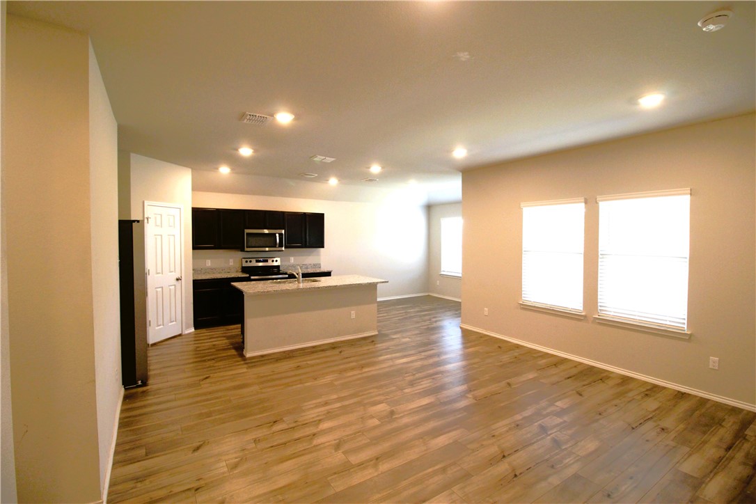 7009 Guadalupe Road China Spring, TX 76633 - Photo 3 of 20 a large kitchen with kitchen island a sink wooden floor and stainless steel appliances