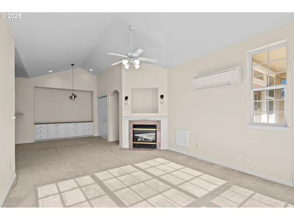 an empty room with windows and fireplace