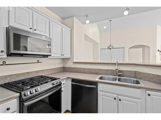 a kitchen with stainless steel appliances granite countertop a sink stove and cabinets