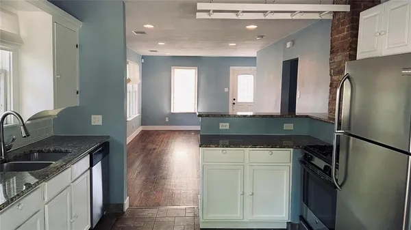 a kitchen with stainless steel appliances granite countertop a refrigerator and a sink