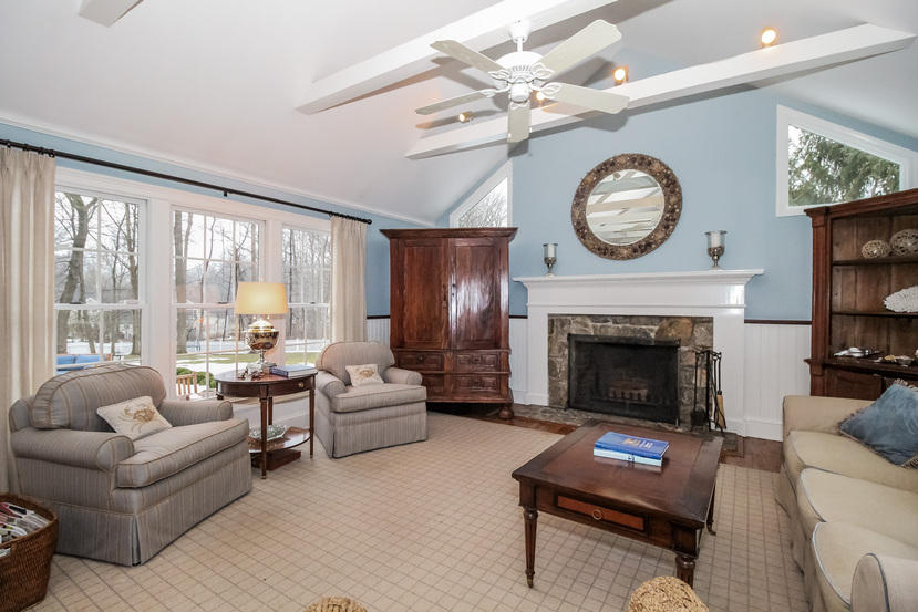123 Brookside Road Darien, CT 06820 - Photo 10 of 39 a living room with furniture a fireplace and a large window