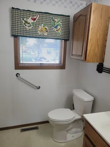 a bathroom with a toilet sink and mirror