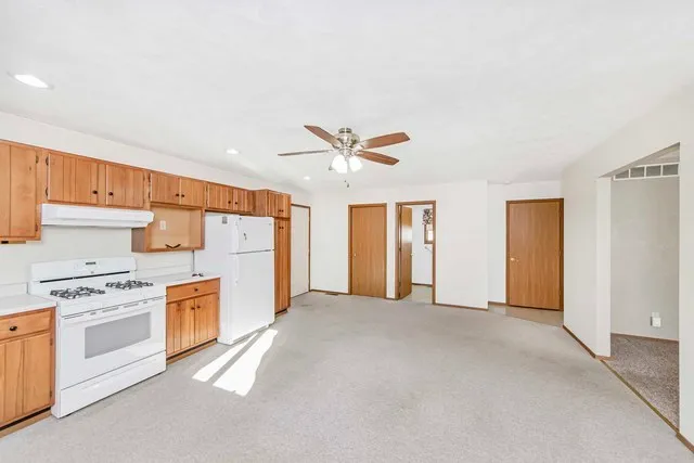 a view of a kitchen with a stove top oven and cabinets