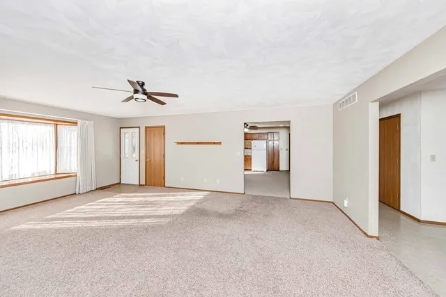 a view of an empty room with window and cabinet