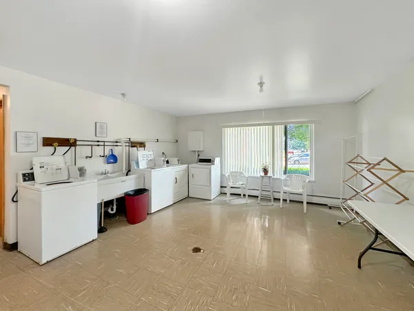 a living room with furniture and white kitchen
