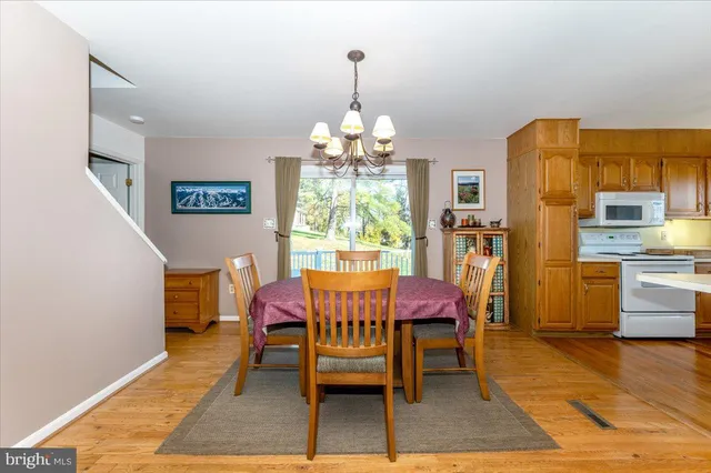 a view of a dining room with furniture a chandelier and wooden floor