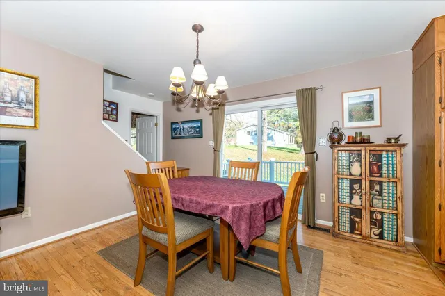 a dining room with furniture a chandelier and wooden floor