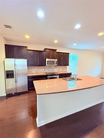 a large kitchen with kitchen island a large counter top and a sink