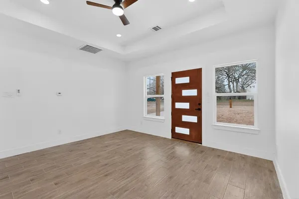 a view of an empty room with a window and a ceiling fan