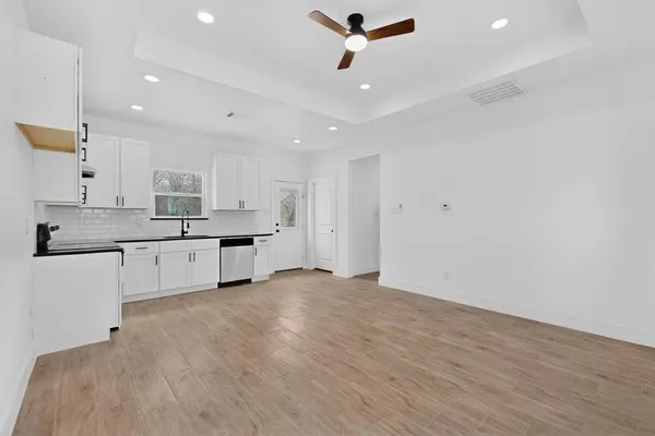 a large white kitchen with kitchen island a sink stainless steel appliances and cabinets