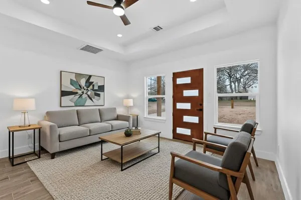 a living room with furniture a bookshelf and a window
