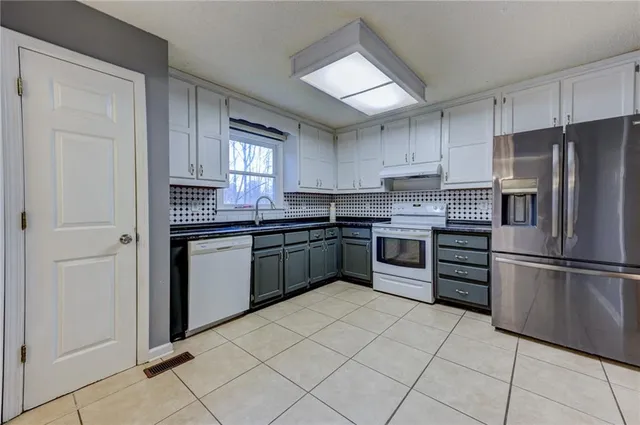 a kitchen with stainless steel appliances a refrigerator sink and cabinets