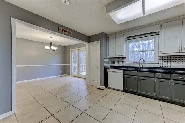 a kitchen with granite countertop a sink window and cabinets