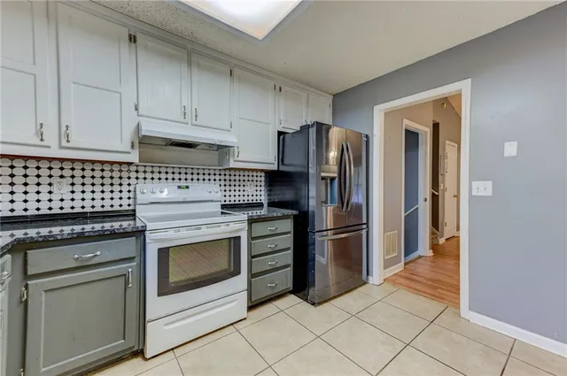 a kitchen with a stove top oven and refrigerator