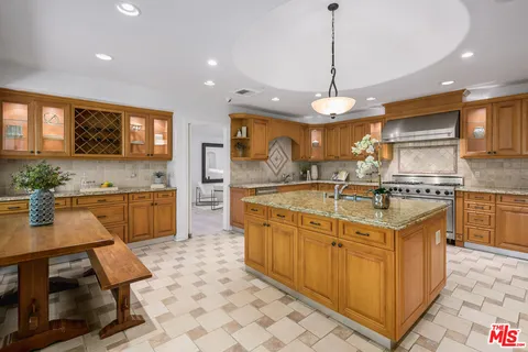 a large kitchen with stainless steel appliances granite countertop a stove and a sink