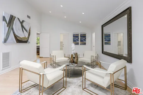 a living room with furniture potted plant and a table